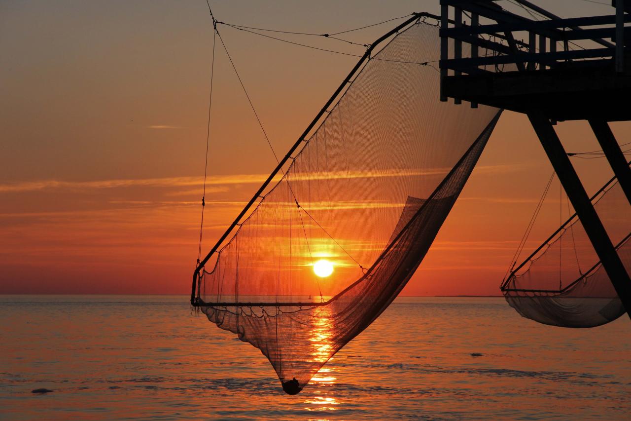 coucher de soleil sur les carrelets de la grande côte face à Cordouan